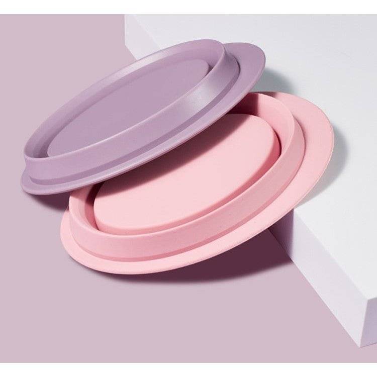 Set de accesorii din silicon pentru curățarea pensulelor și bureților de machiaj, în culori roz și mov, design pliabil și practic.