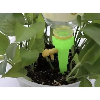 Picurator reglabil pentru plante, verde, montat într-un ghiveci pentru irigare automată. Perfect pentru menținerea umidității solului.