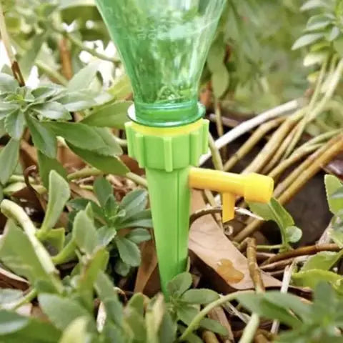 Dispozitiv de irigare picurare pentru plante, verde, utilizat cu sticlă de plastic pentru udare constantă a florilor și plantelor de apartament.