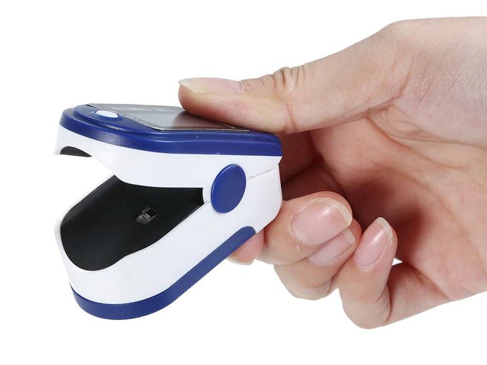 Pulsoximetru digital alb/albastru tinut in mana, design ergonomic pentru masurarea rapida a SpO2 si pulsului. Disponibil la Cumpara24 la pret special!