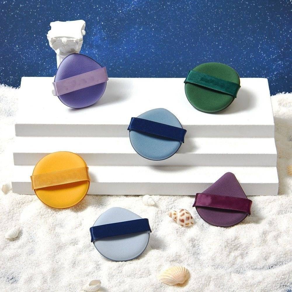 Set de bureți de machiaj în diverse culori, expuși pe un suport alb. Accesorii esențiale pentru un machiaj impecabil.