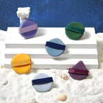 Set de bureți de machiaj în diverse culori, expuși pe un suport alb. Accesorii esențiale pentru un machiaj impecabil.